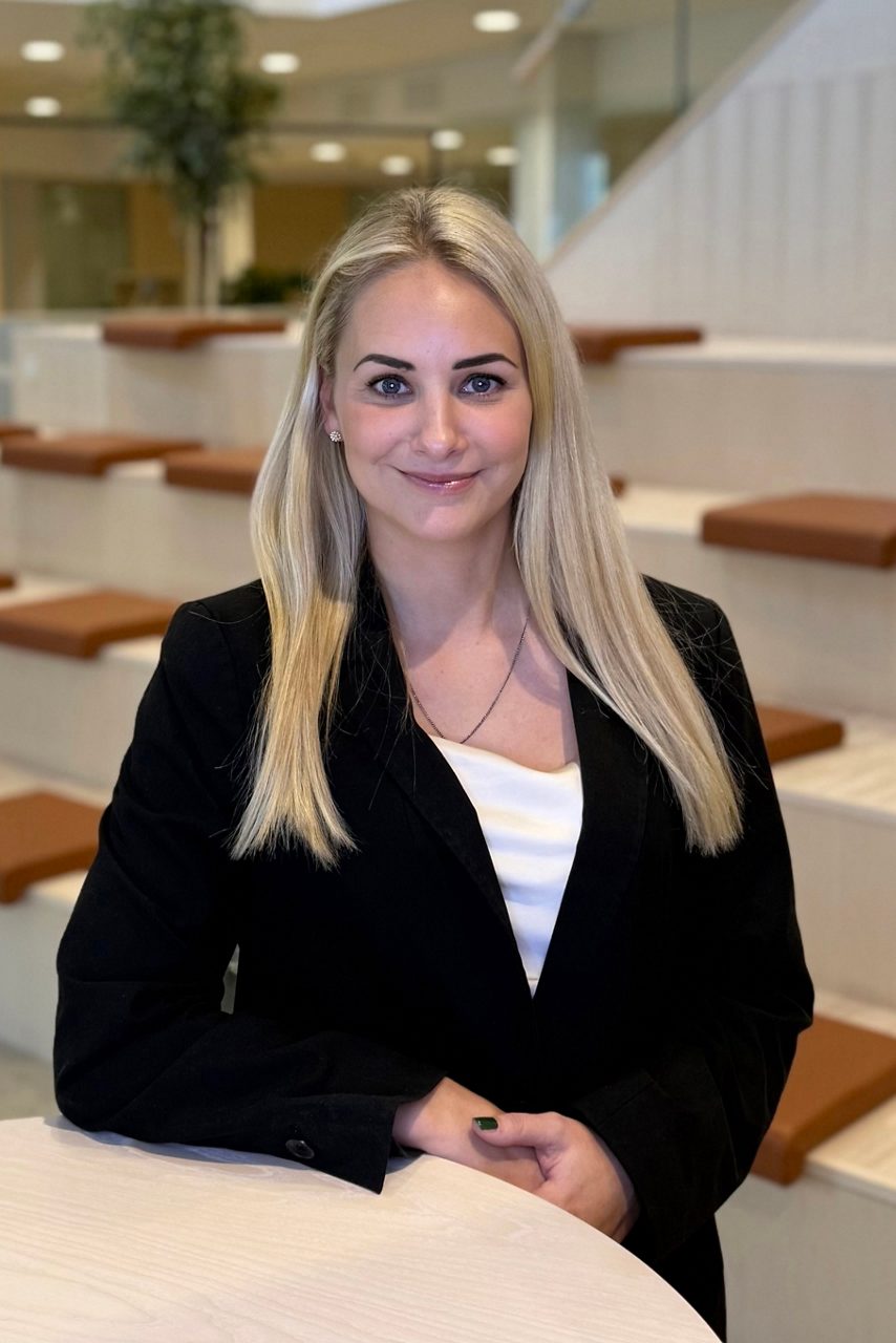 Kvinna tittar in i kameran och ler