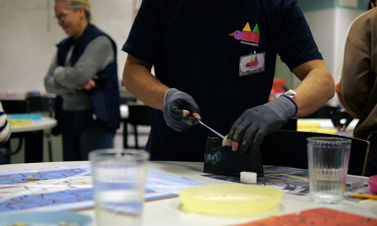 En man som ska tejpa mosaik