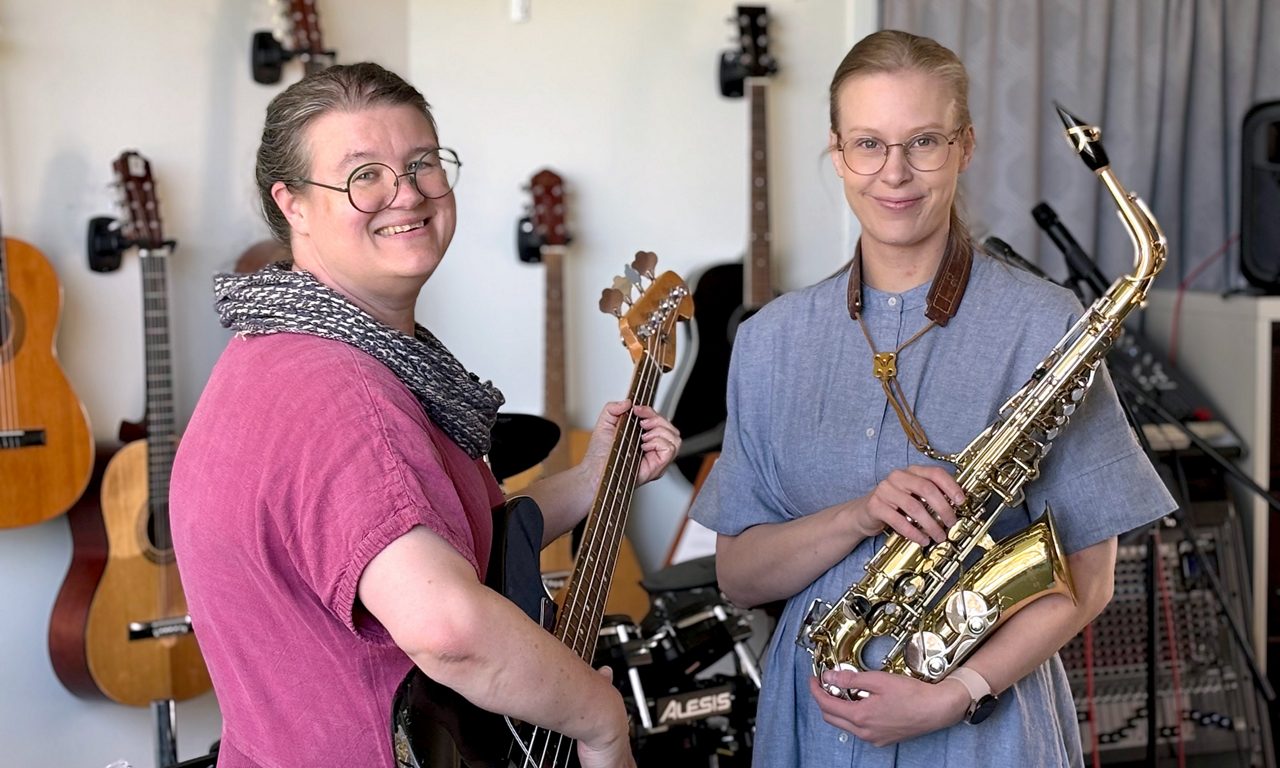 Två kvinnor håller i var sitt instrument