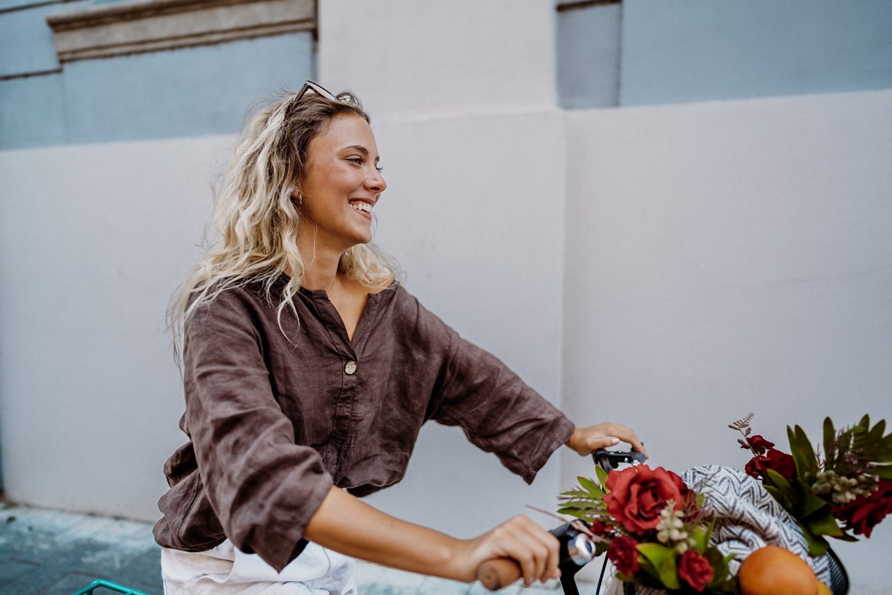 Glad blond kvinna cyklar