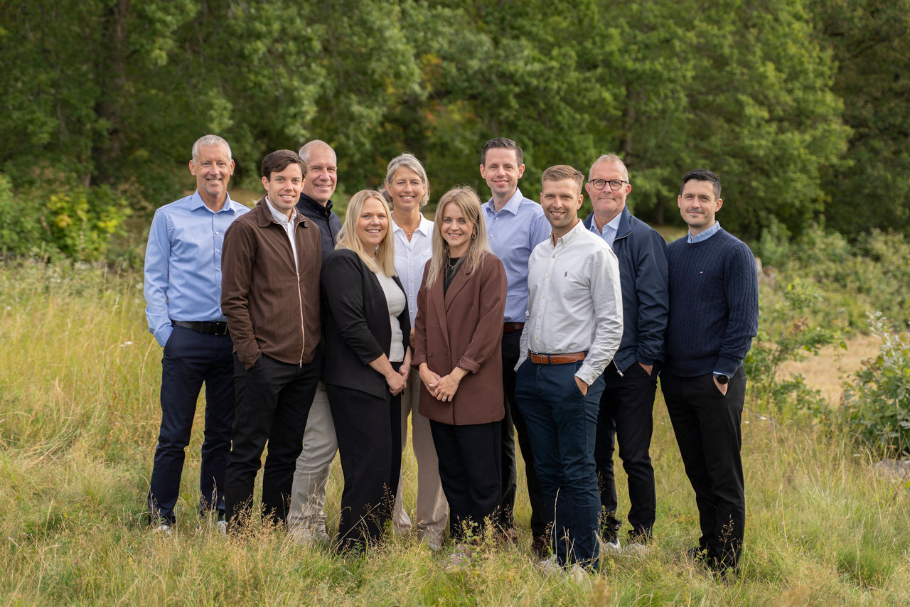 All personal som arbetar med företagskunder på Tidaholms Sparbank står tillsammans med en skog i bakgrunden.