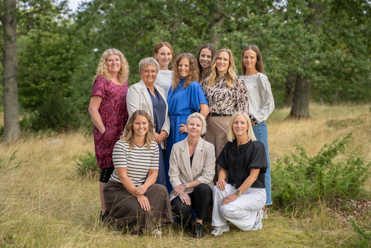 All personal som arbetar med administrativa uppgifter på Tidaholms Sparbank står tillsammans med en skog i bakgrunden.