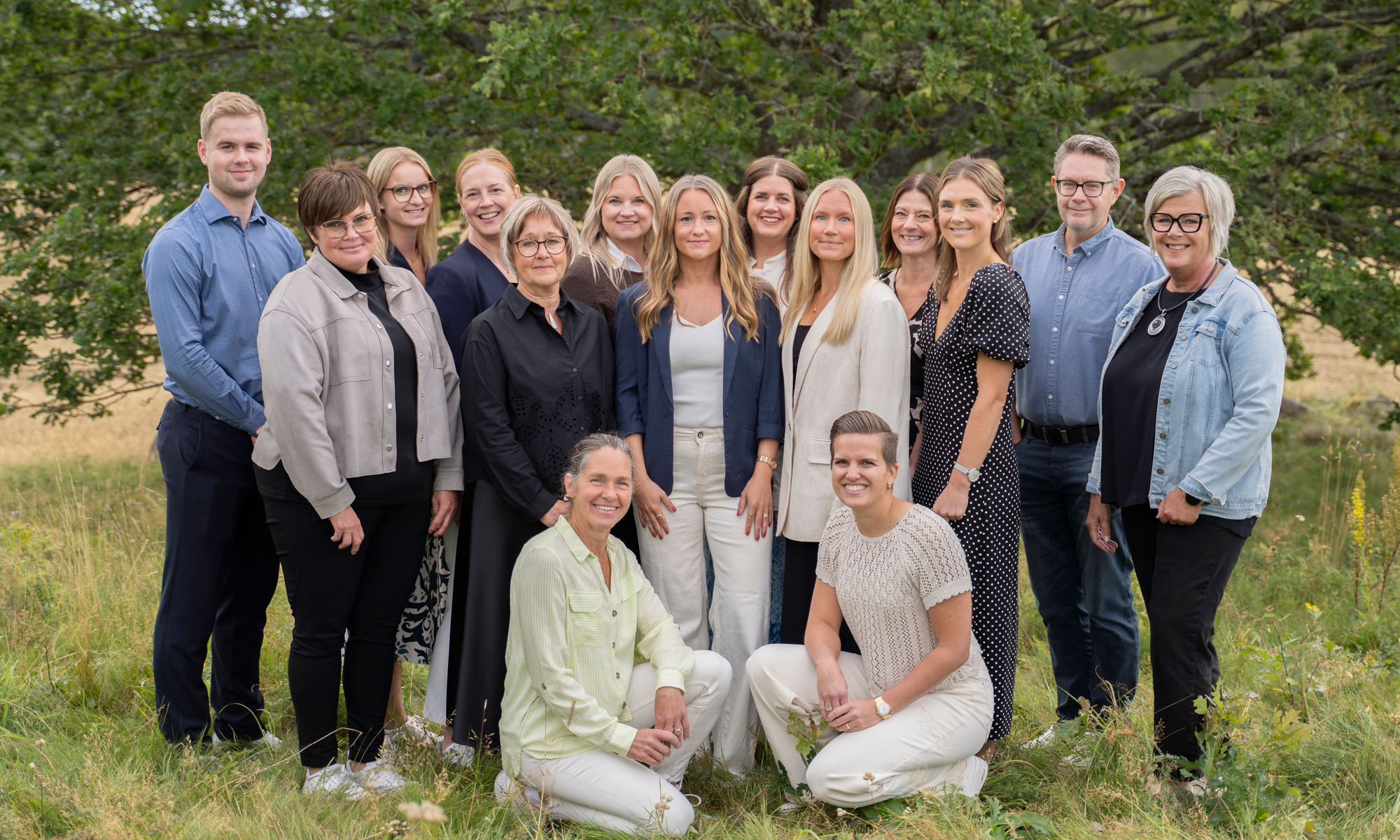All personal som arbetar med privatkunder på Tidaholms Sparbank står tillsammans med en stor ek i bakgrunden.