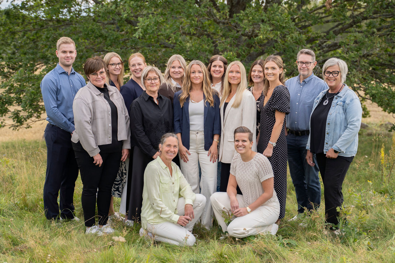 All personal som arbetar med privatkunder på Tidaholms Sparbank står tillsammans med en stor ek i bakgrunden.