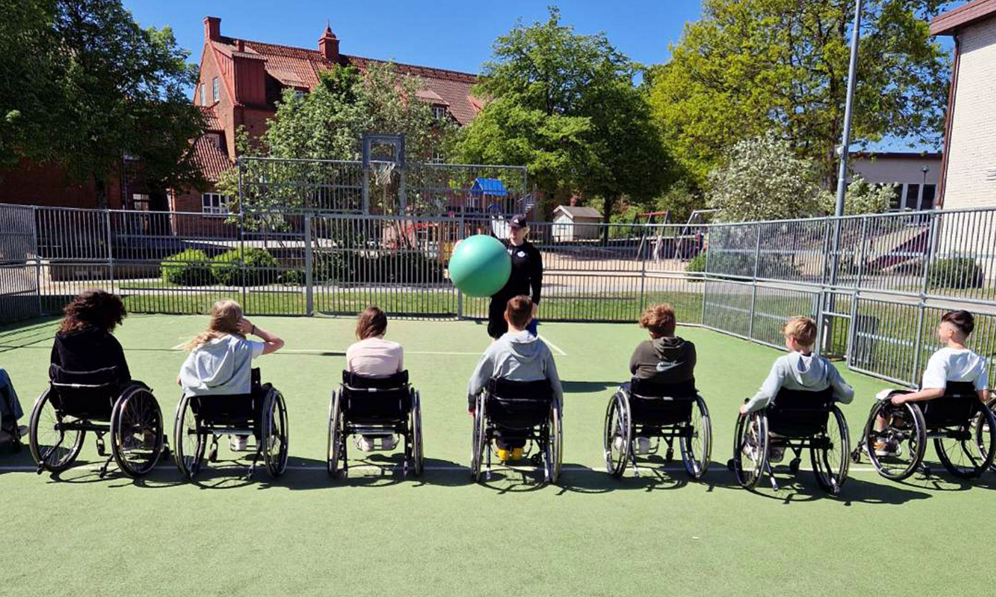 Elever i rullstolar på en idrottsbana.