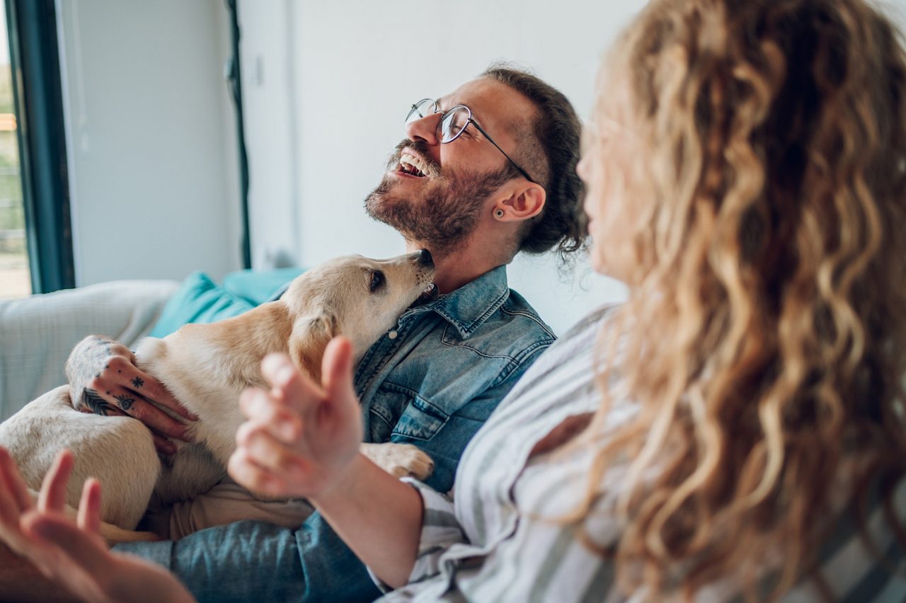 A couple cuddles with a dog