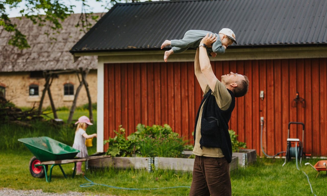 Man med sina barn i trädgården