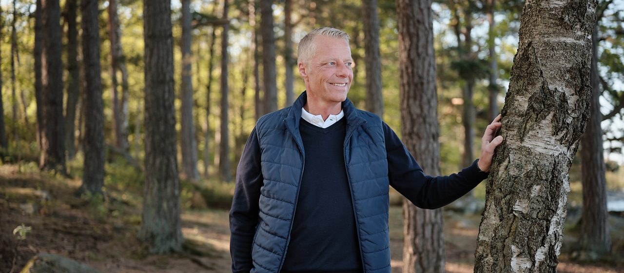 En man som lutar mot ett träd