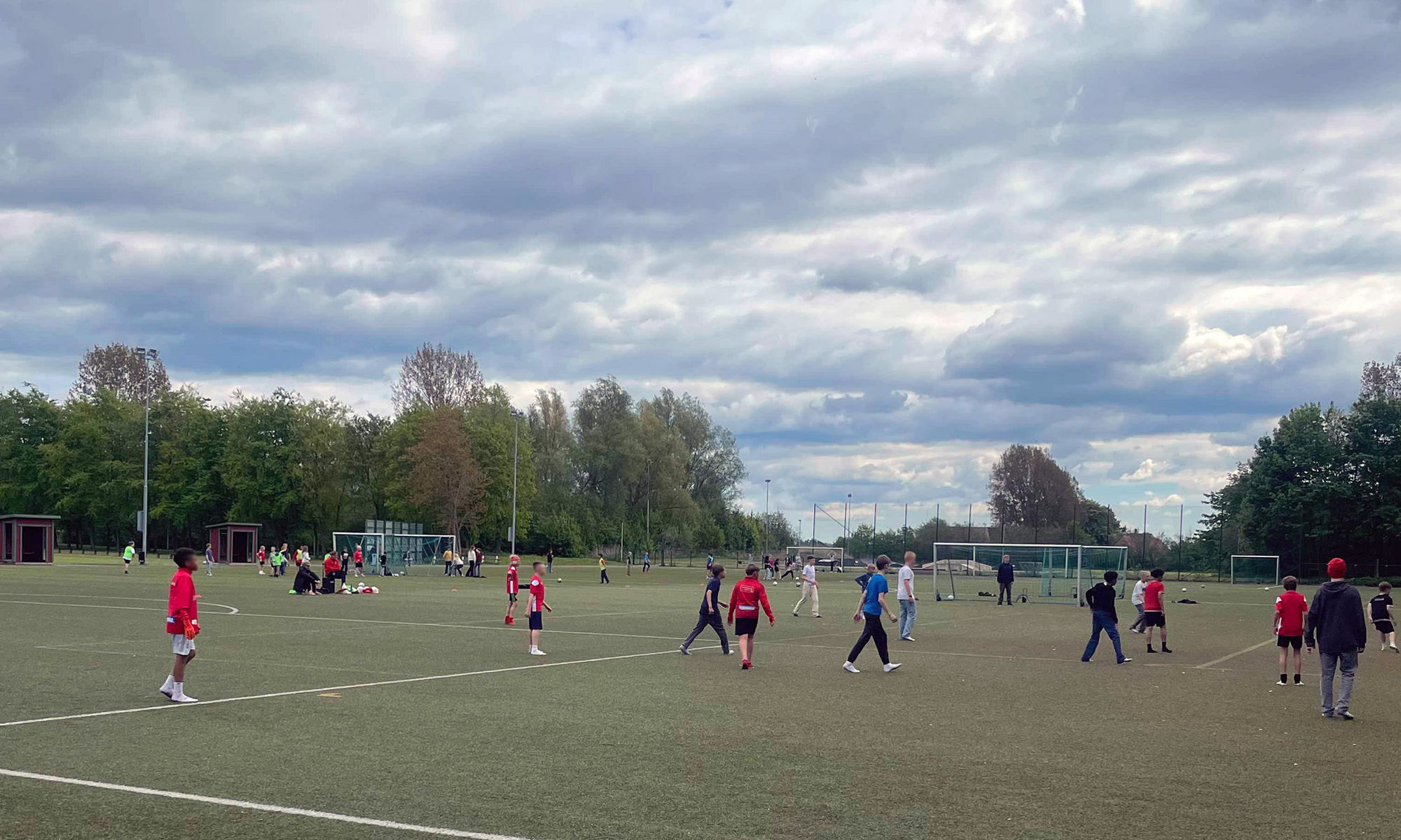 Barn spelar fotboll på en fotbollsplan.