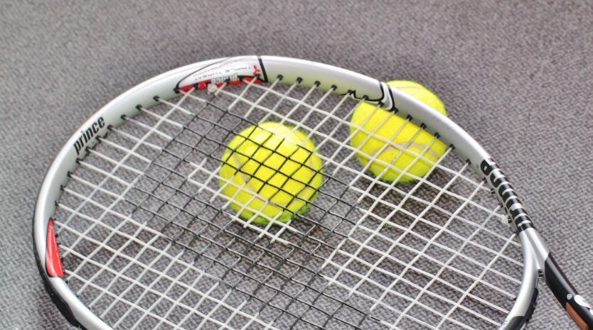 Tennisrack och två tennisbollar