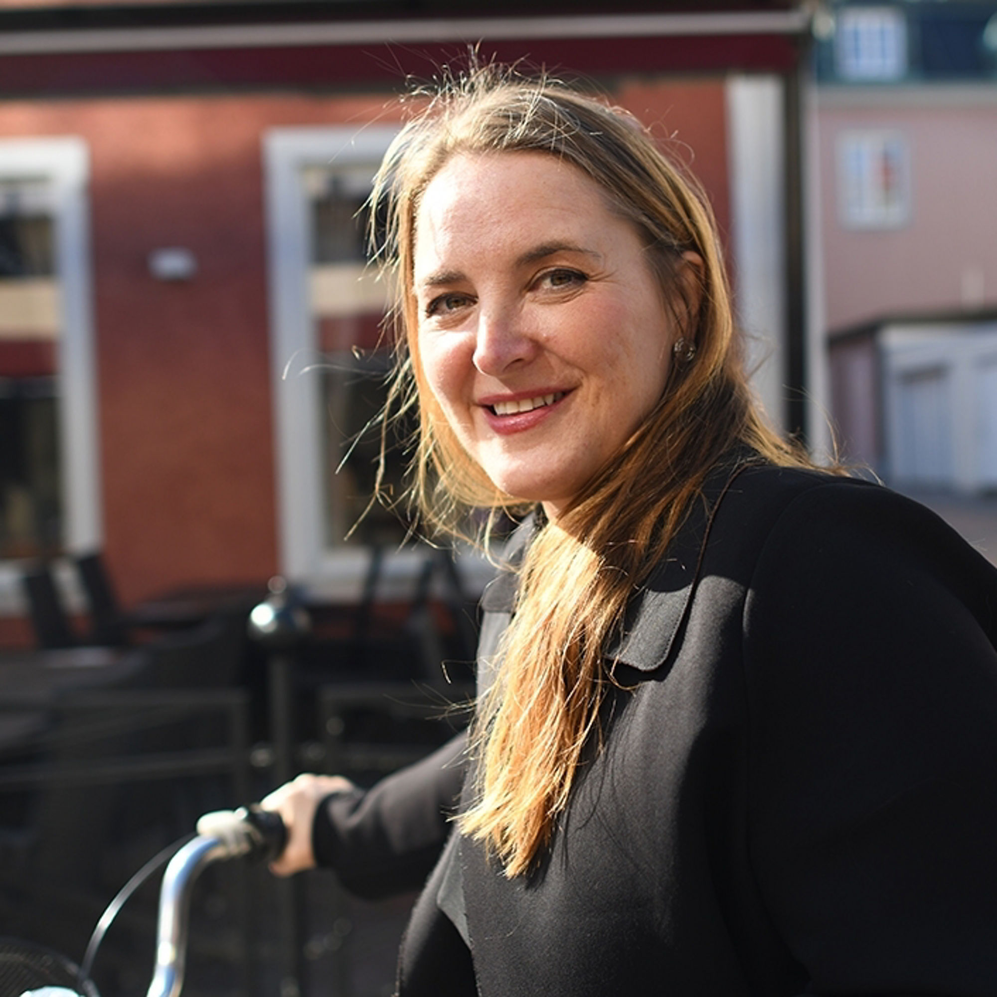 Rådgivare Therese Löwenstam Aupers står framför ett hus med en cykel