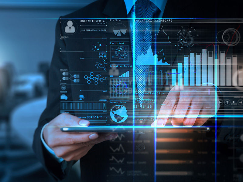 Un hombre sujetando una tableta que proyecta un panel de control de datos de TI mejorados