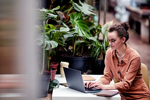 Femme assise à un bureau et travaillant sur son ordinateur portable