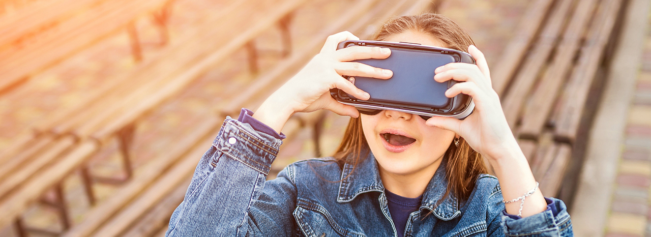 Junges Mädchen lacht und schaut durch eine VR-Brille