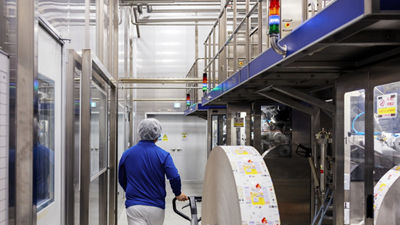 Worker walking through an automated food packaging facility.