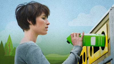 Woman recycling a carton in a recycling bin