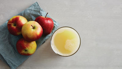 Äpfel und ein Glas saft von oben fotografiert