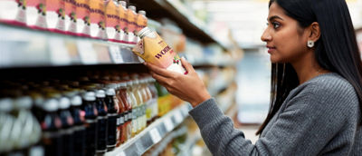 Woman in store looking at healthy-beverages on shelf