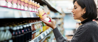 Donna in negozio che guarda le bevande salutari sullo scaffale