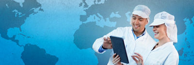 Dos expertos en batas de laboratorio viendo una tableta