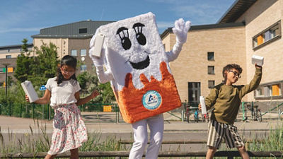 Glada barn som dansar med en dryckeskartong