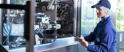 hombre mirando una máquina con una tableta