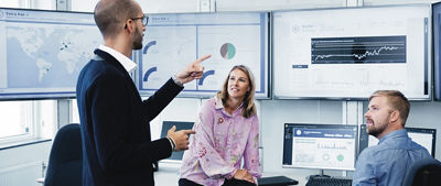 People discussing and reviewing data on screens