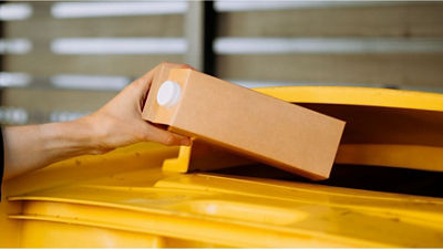 Hand throwing a carton package in the bin