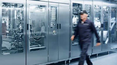 Ingeniero de servicio caminando cerca de una máquina de llenado