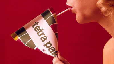 Woman drinking from carton through a straw