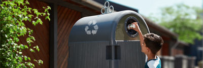 kid recycling carton in bin