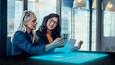 Deux personnes discutent en regardant un document.