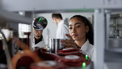 Una donna regola l'attrezzatura tecnica con attenzione e concentrazione.