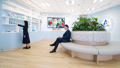 两个人正悠闲地参观一间现代化展厅，展厅四周墙壁均采用创意包装装饰。