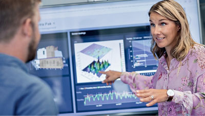 Dos personas analizan un diagrama completo en una pantalla de computadora.