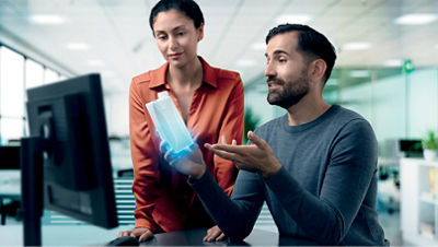 Dos colegas analizan un envase frente a una computadora.