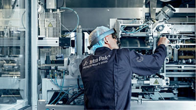  A man operates a machine in a factory, focused on his task.
