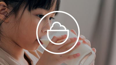 Child drinking a glass of milk with a nutrition symbol overlay