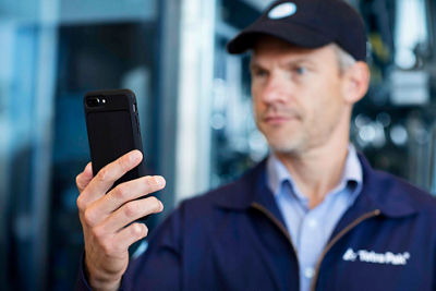 Man in blue overalls talking to a woman at a machine