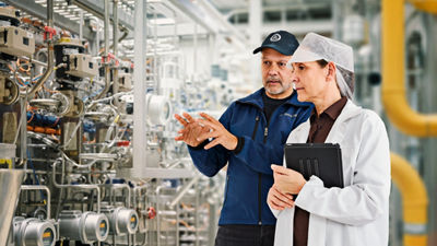 workers in factory looking at machine