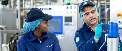 mulher olhando para um homem apontando para uma máquina 