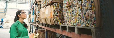 Woman and bales with cartons for recycling