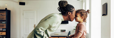 Mãe dando carinho em filha por retorno das aulas