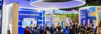 Estande da Tetra Pak Brasil em feira, com visitantes circulando, letreiro suspenso, painéis sobre inovação e embalagens e elementos verdes no espaço da NaturalTech 2026.