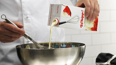 Chef Pouring Whipping Cream Into Mixing Bowl