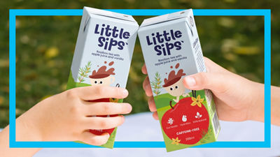Children hands holding little sips tea packages.