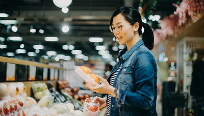 Woman shopping fruit at market in asia