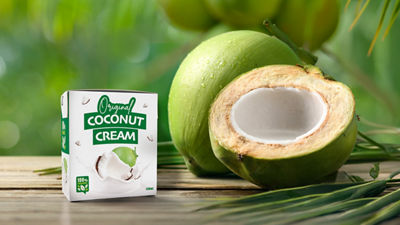 coconut cream in carton next to open coconut