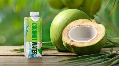 coconut water in carton next to an open coconut