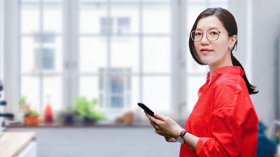 一位手拿电话站在厨房里的女士